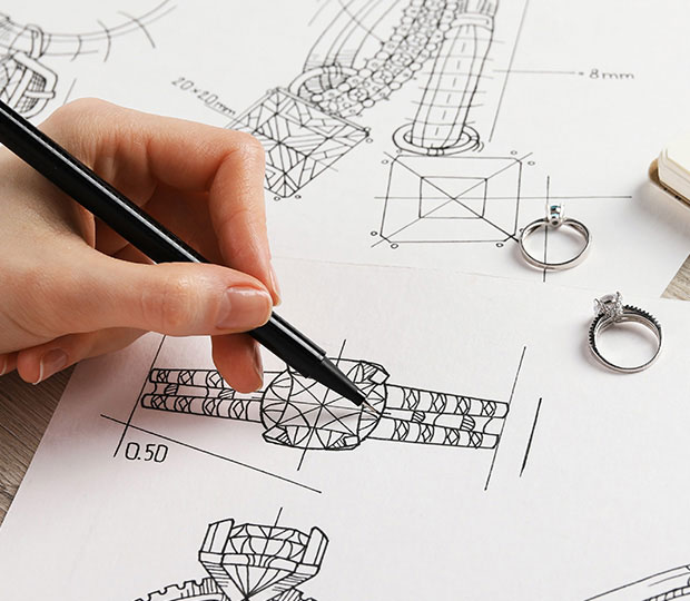 Person sketching a ring design on a piece of paper