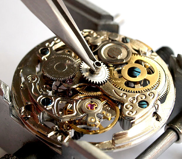 A deconstructed watch being repaired