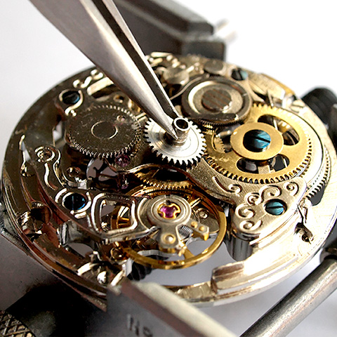A deconstructed watch being repaired