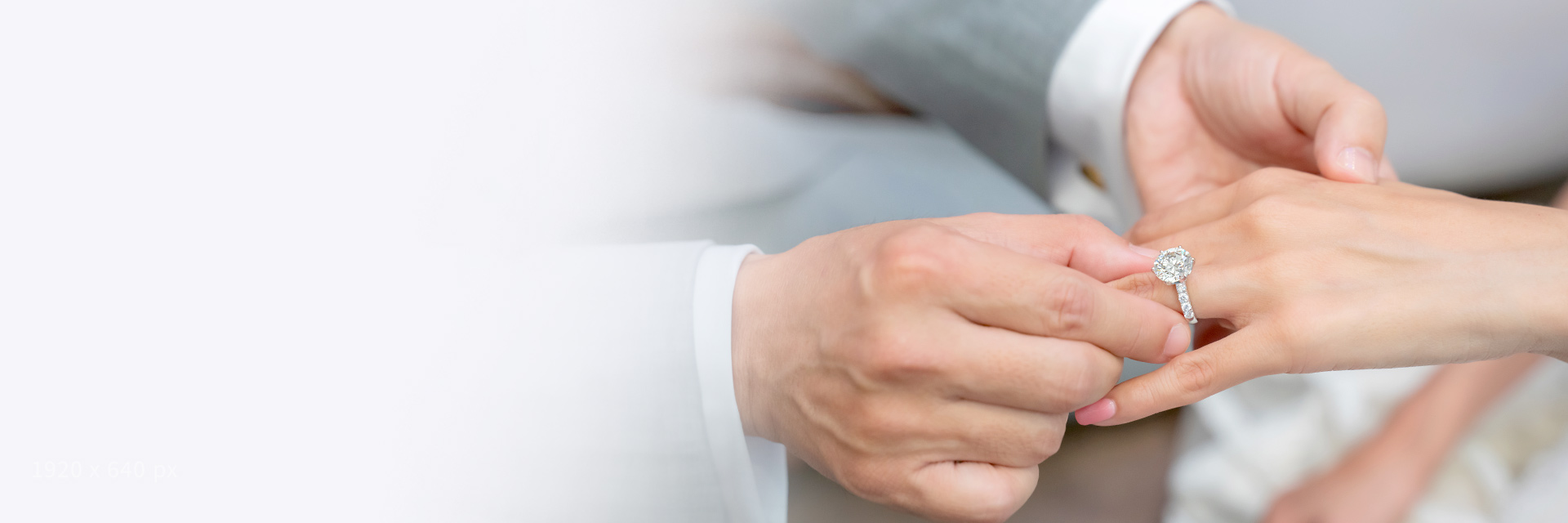 Man placing an engagement ring onto a woman's finger